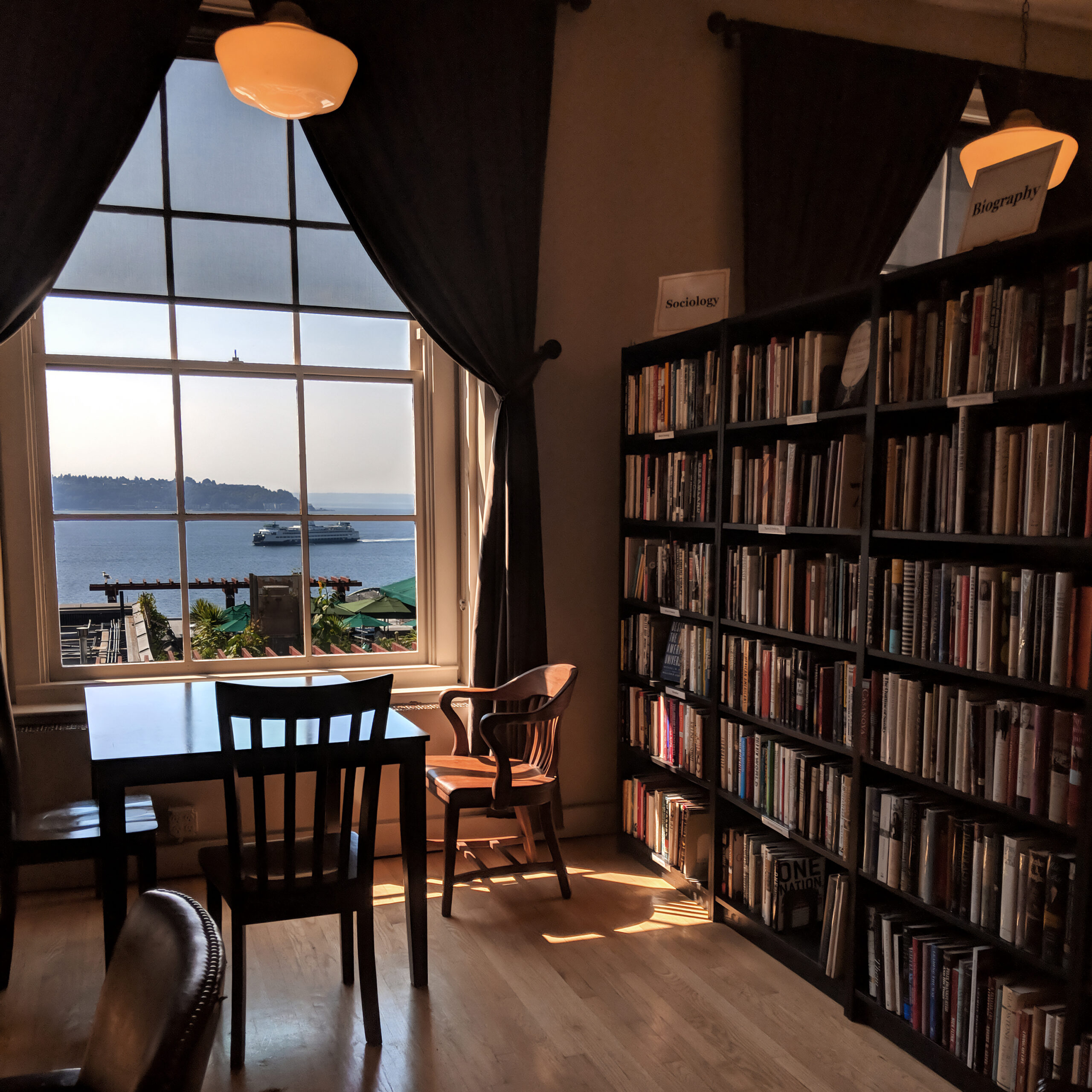 An old-fashioned library with a view of a washington state ferry in the puget sound, located in pike place market.