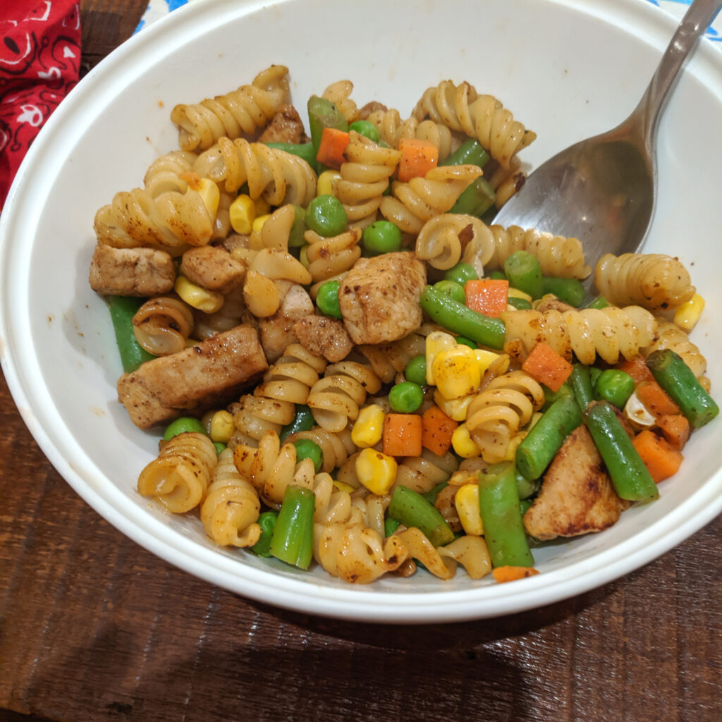 Pasta in a bowl in a hostel kitchen.