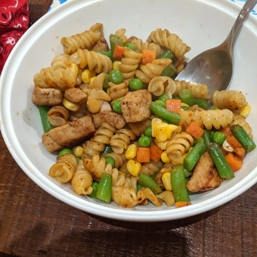 Pasta in a bowl in a hostel kitchen.