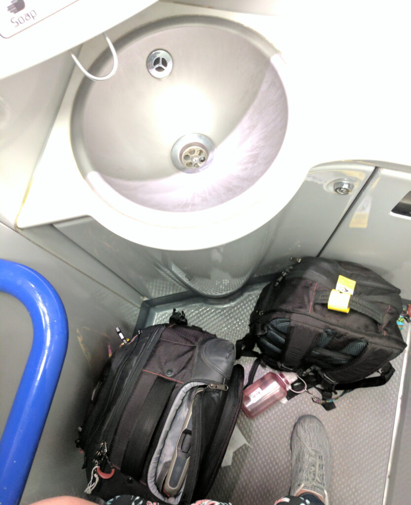Luggage on a bathroom floor in an overnight train.