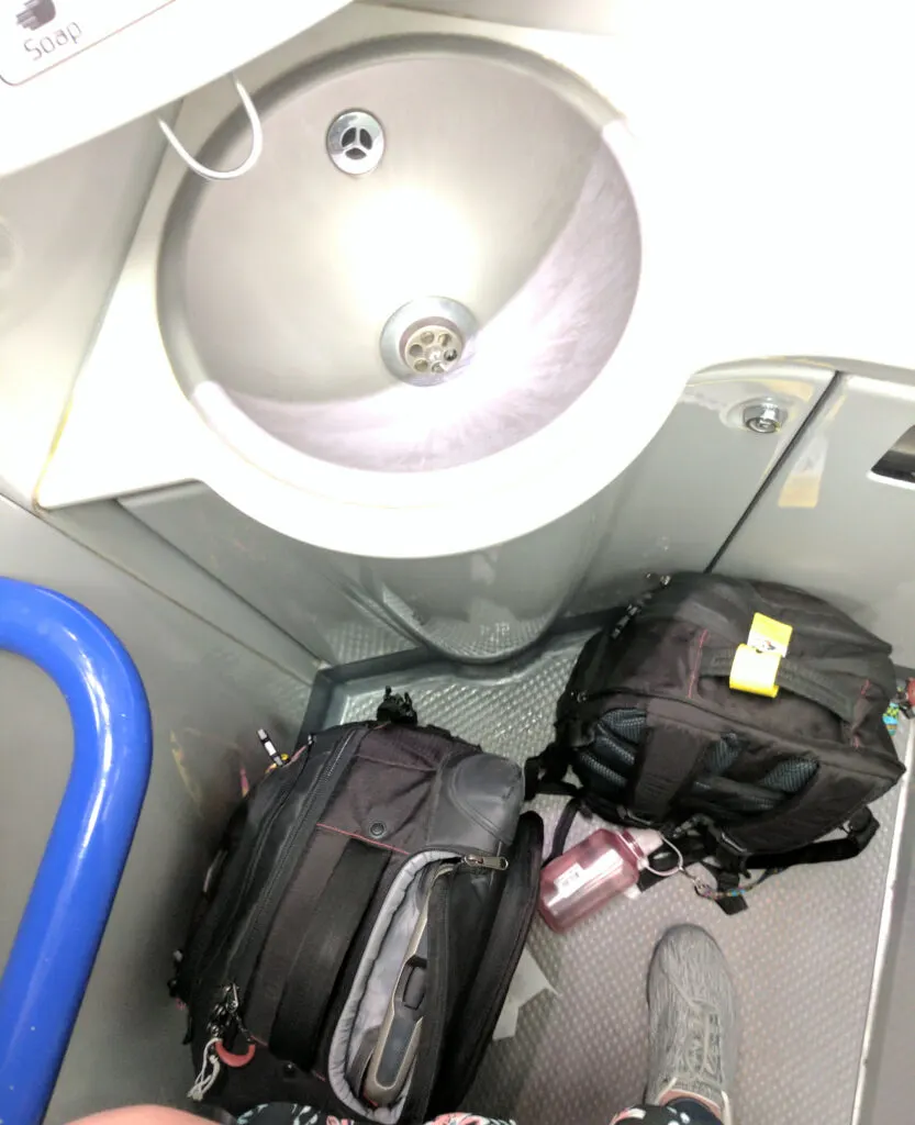 Luggage on a bathroom floor in an overnight train.