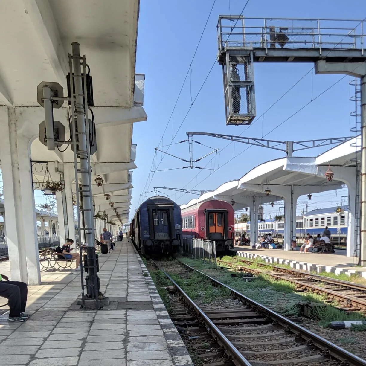 A train pulls into an outdoor train station in eastern europe.
