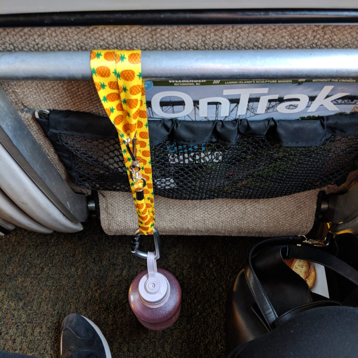 A lanyard tethers a water bottle to the back of the train seat so it can't be dropped.