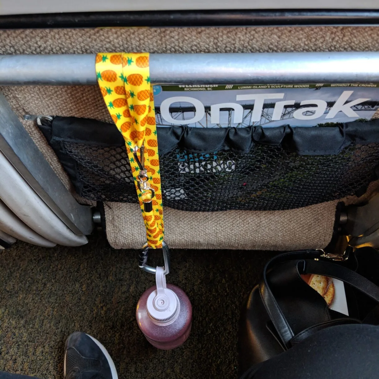 A lanyard tethers a water bottle to the back of the train seat so it can't be dropped.