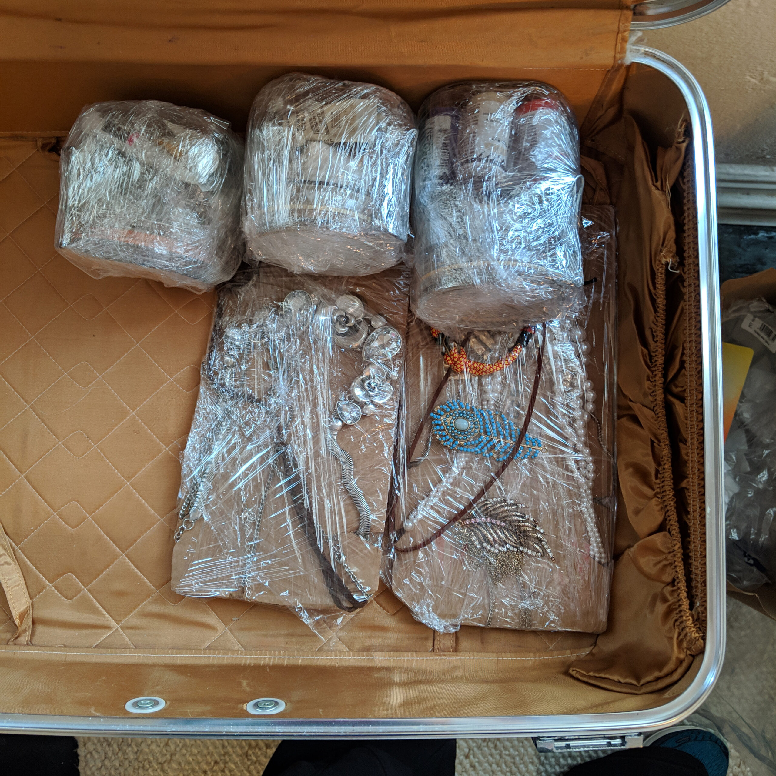 Packing jewelry for travel in a suitcase.