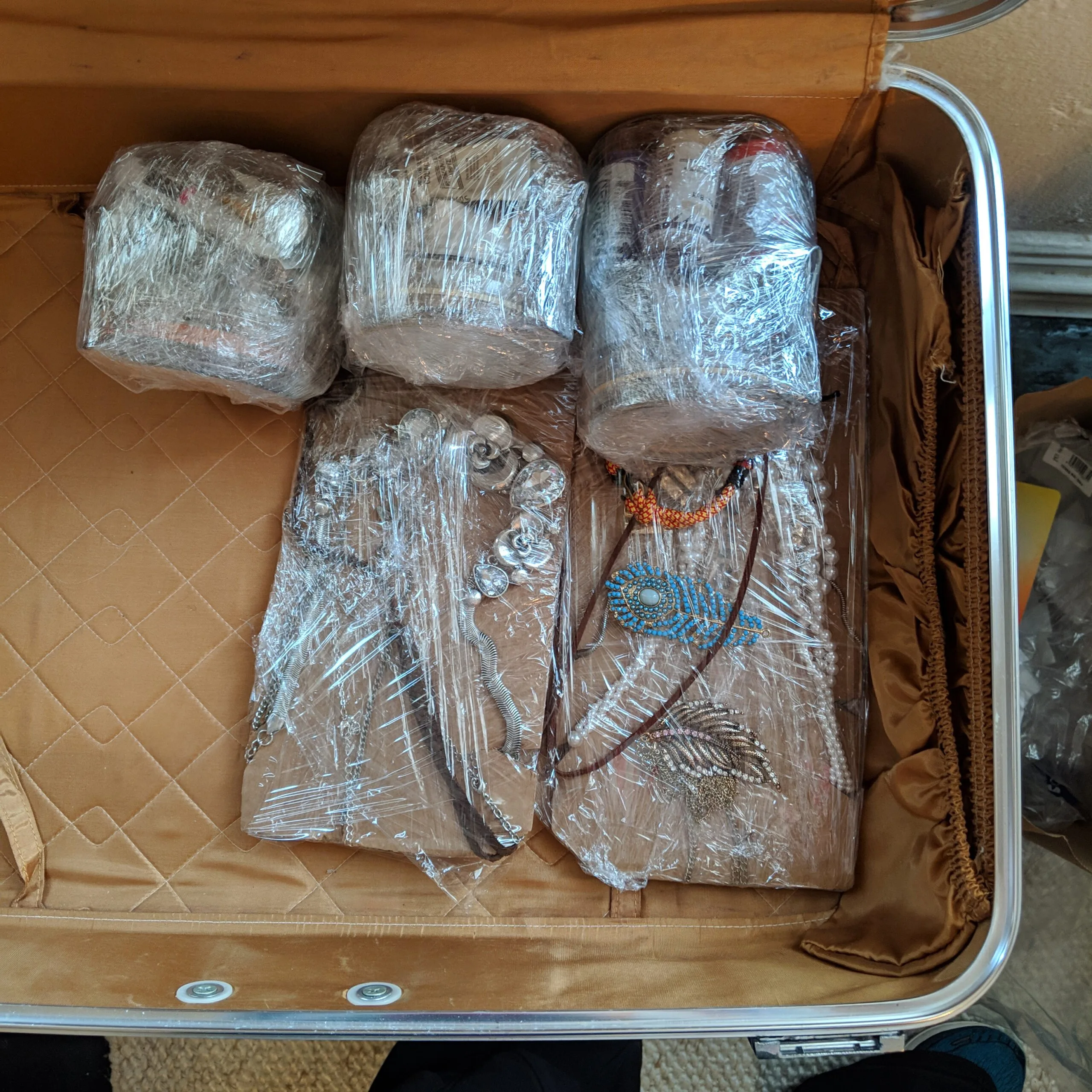 Packing jewelry for travel in a suitcase.