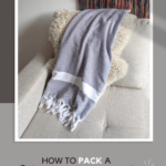 How to pack a carry on bag for your next flight text on image of a scarf on the sofa