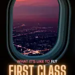 What it’s like to fly first class + 1st class packing list text on image of the view of a city at night from a plane window