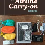 What’s in my airline carry-on in 2022 text on image of a notebook, pouches, headphones, and electronics