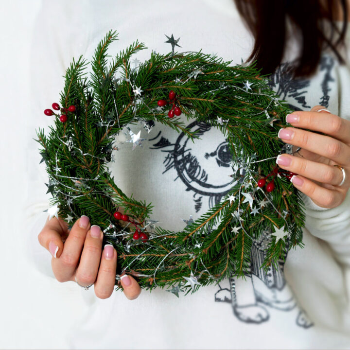Woman holding a Christmas wreath.