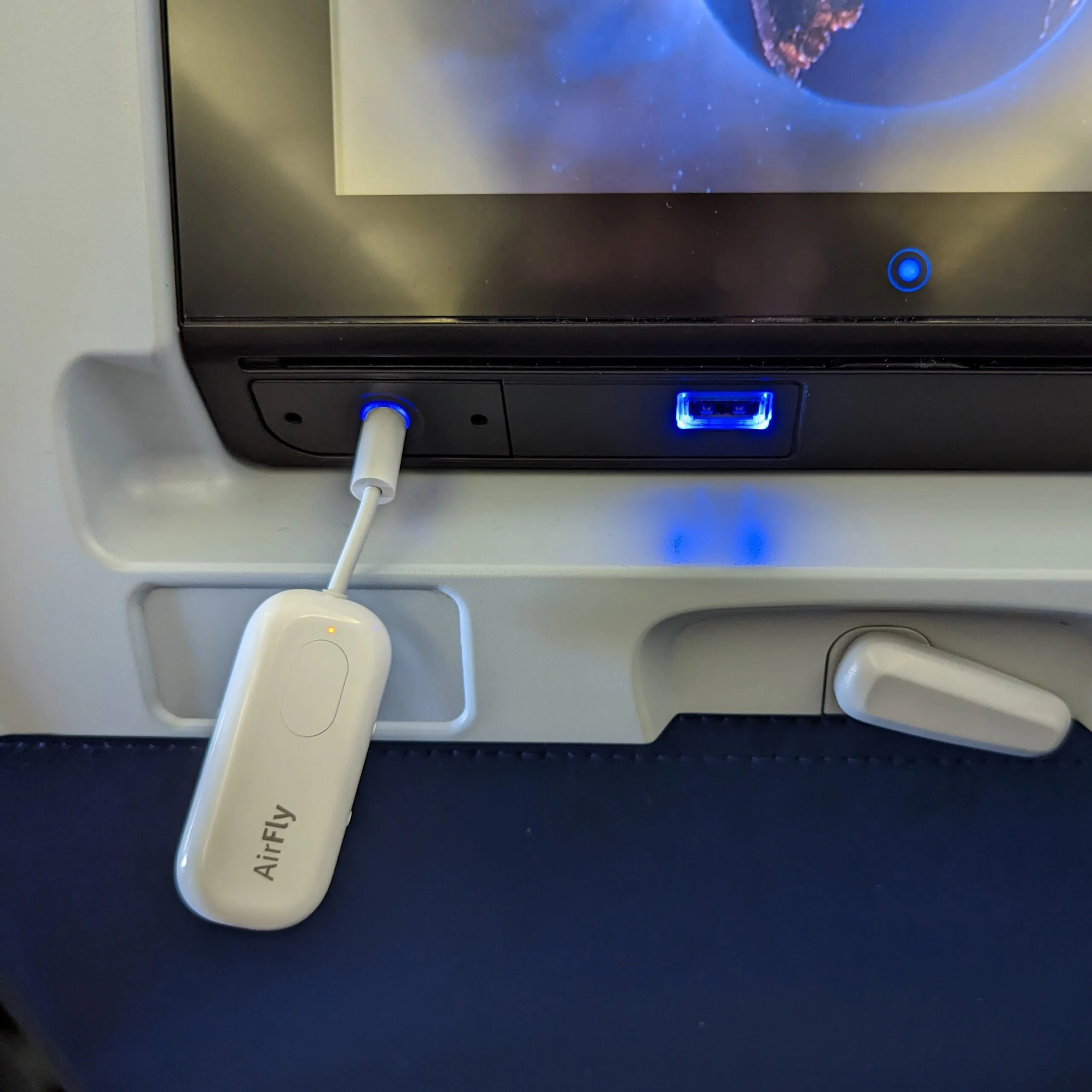 A bluetooth airplane wireless audio converter being used during international flight.