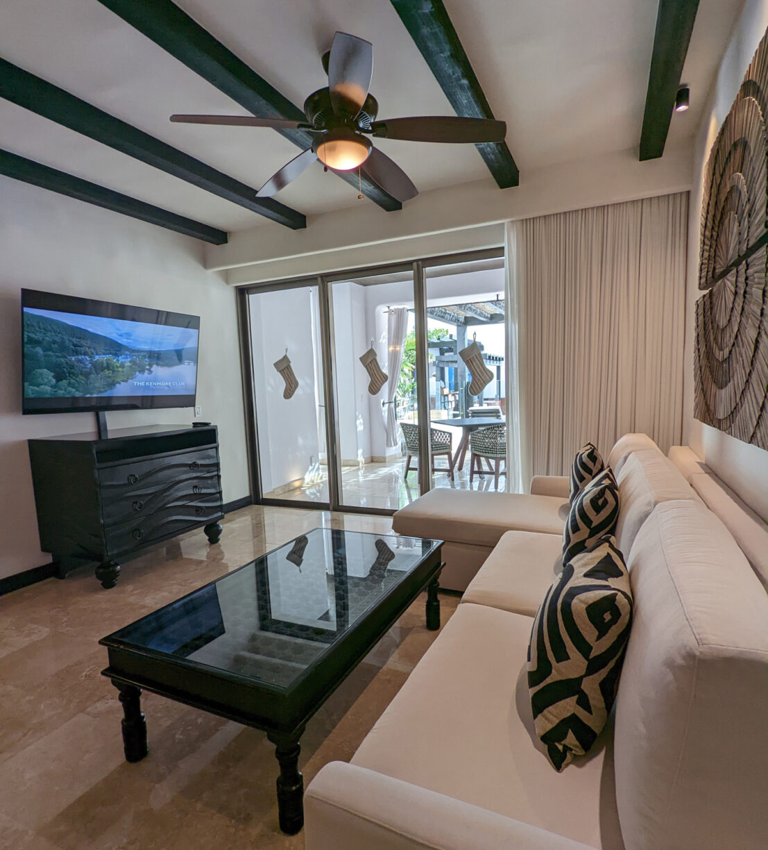 A tropical vacation hotel room decorated for christmas with stockings hung on the balcony.