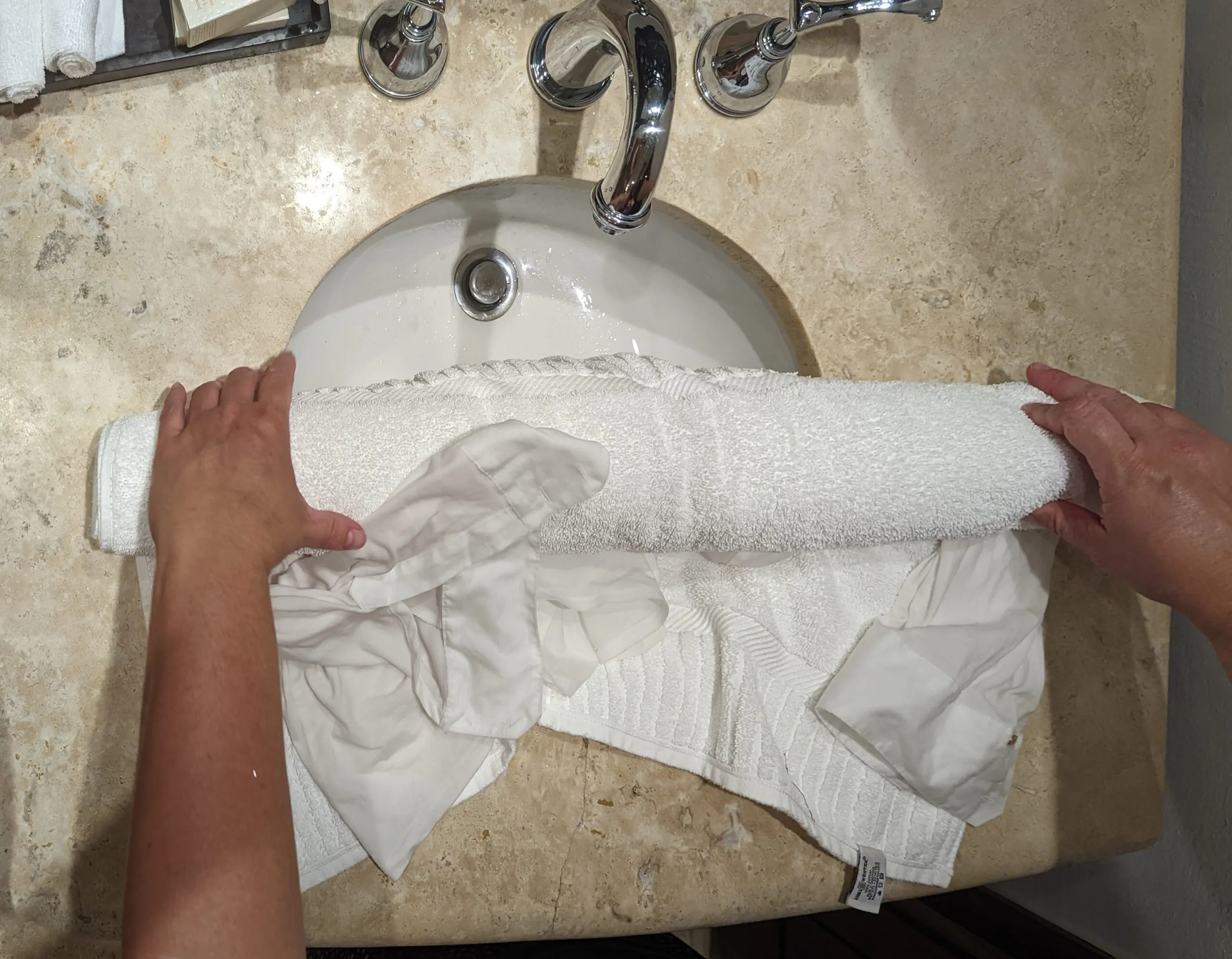 Rolling a wet shirt in a towel to dry.