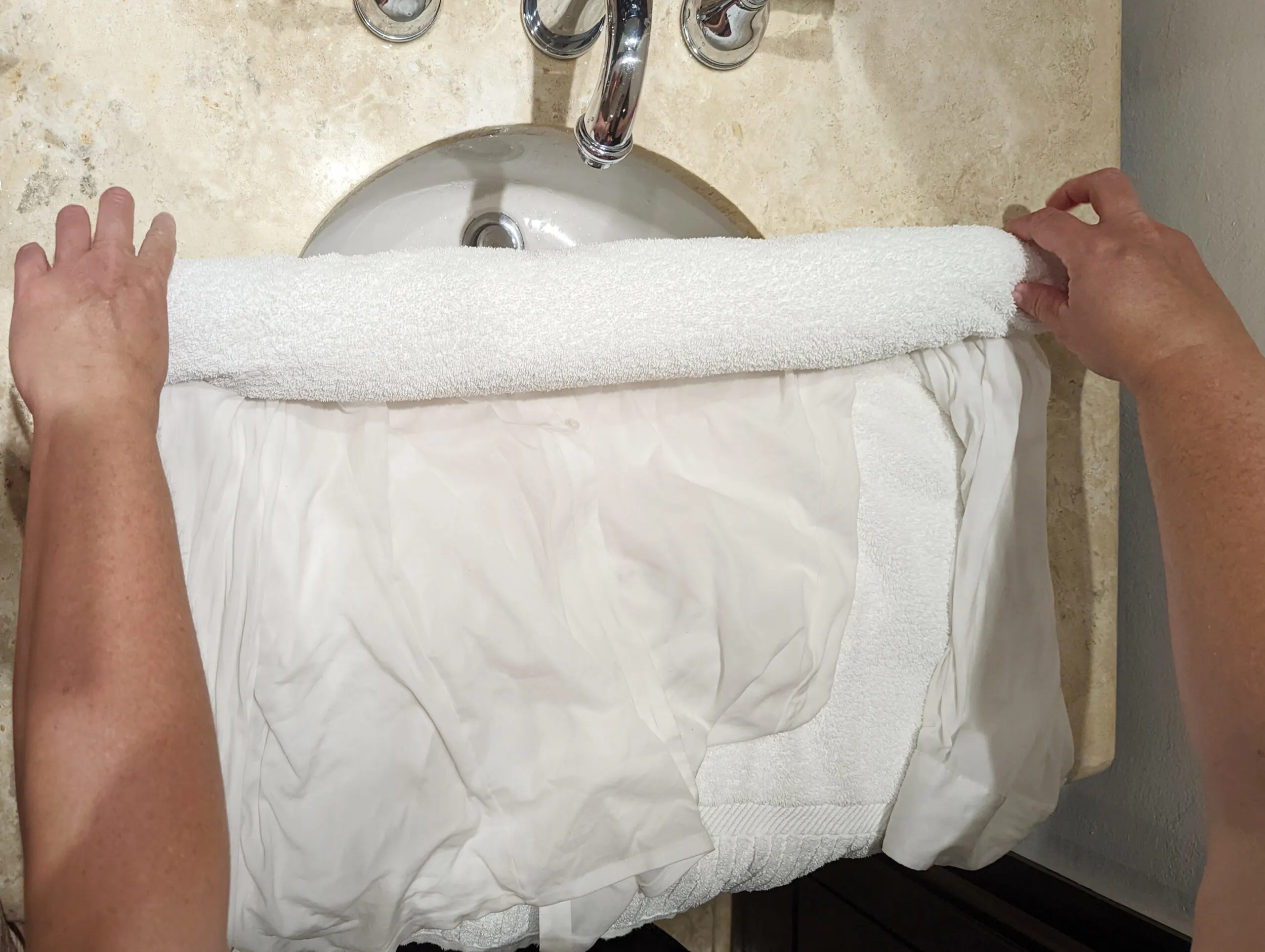Rolling a wet shirt in a towel to dry.