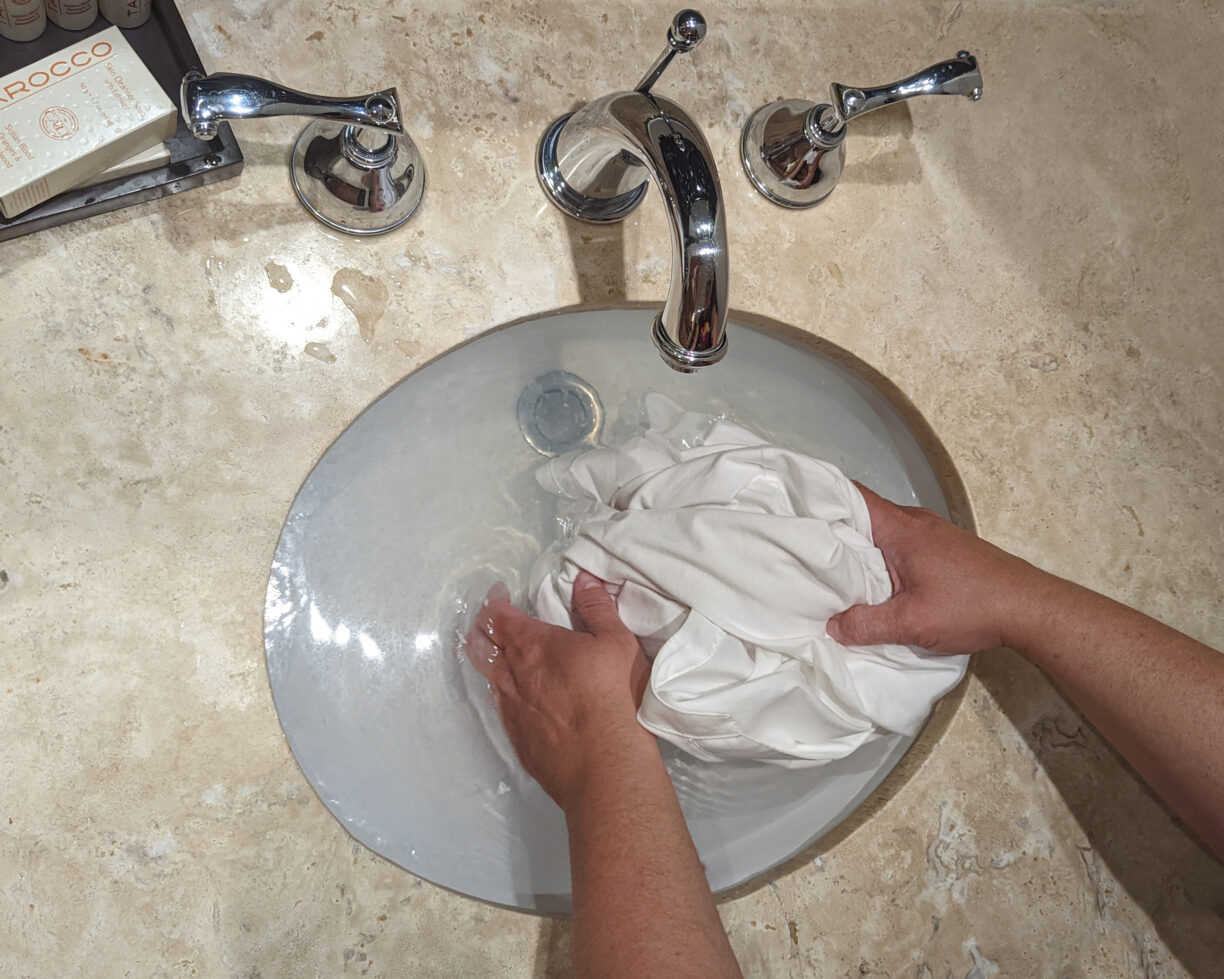 Grating soap into a hotel sink for washing clothes