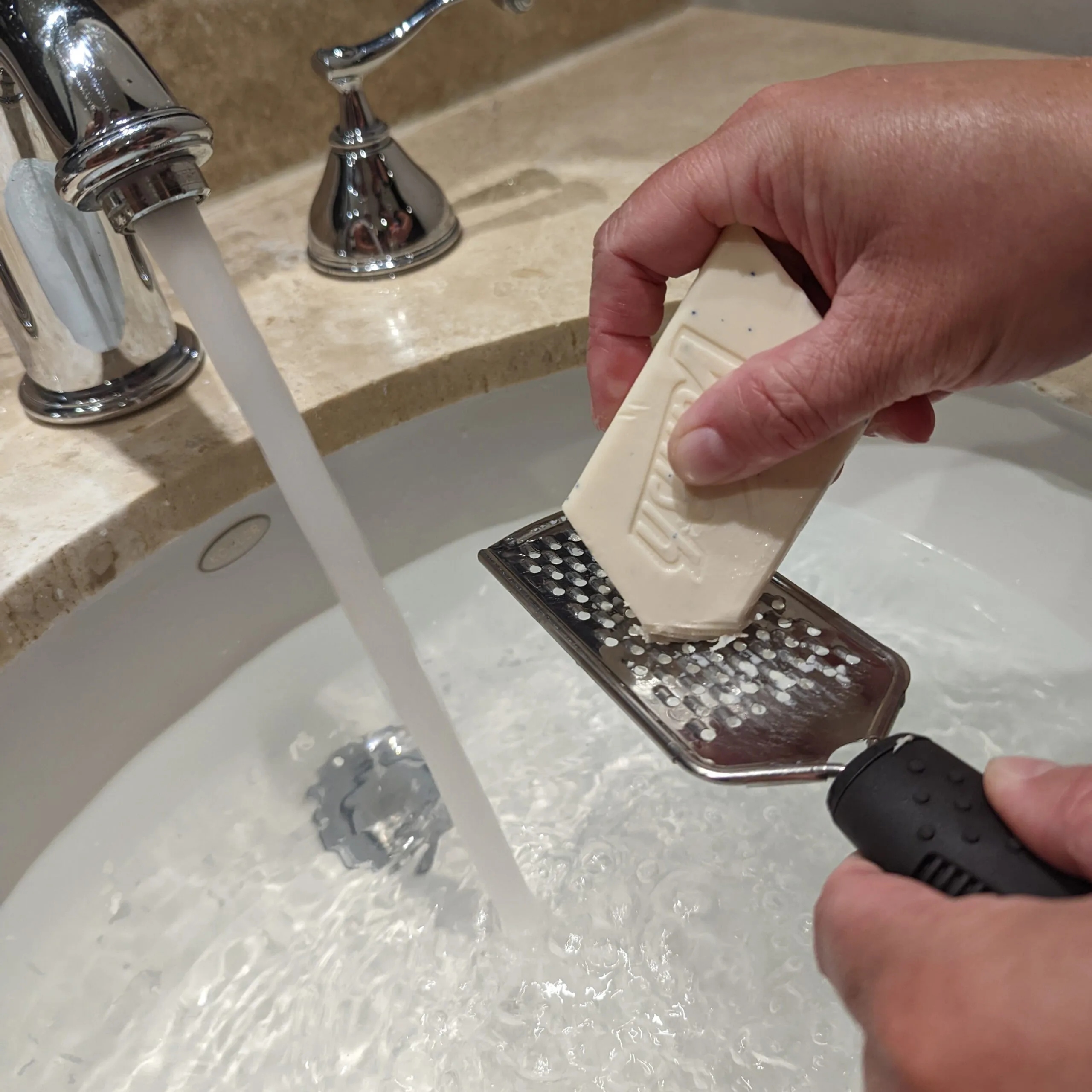 Grating soap into a hotel sink for washing clothes