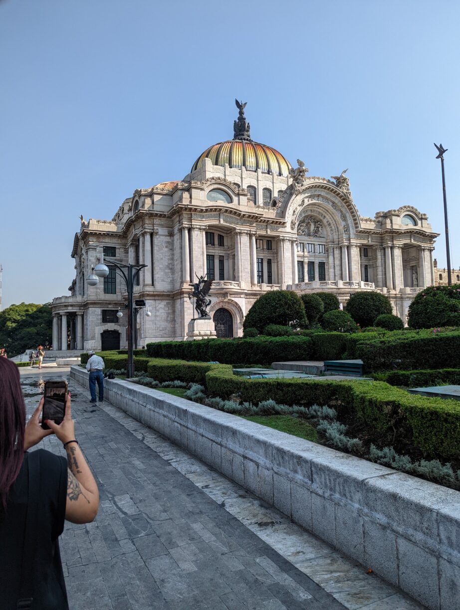 A woman photographs a building in mexico.