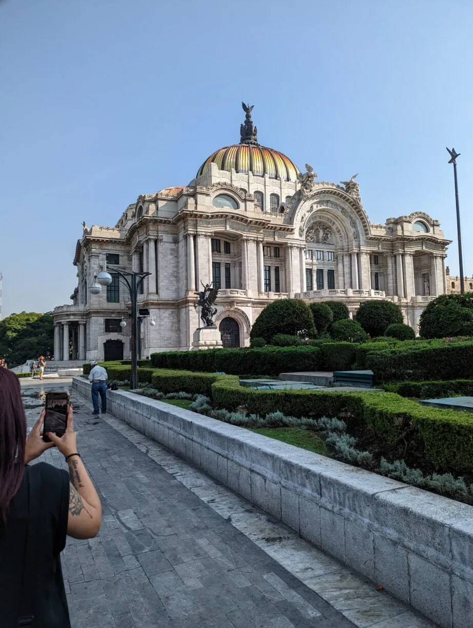 A woman photographs a building in mexico.