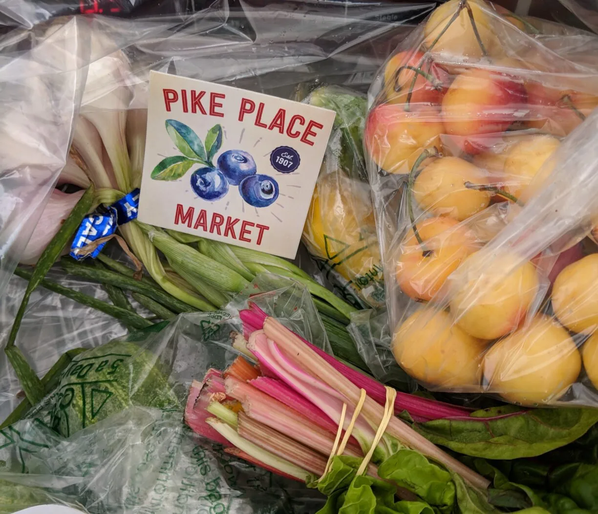 Ranier cherries next to a pike place market sticker in a seattle csa box.