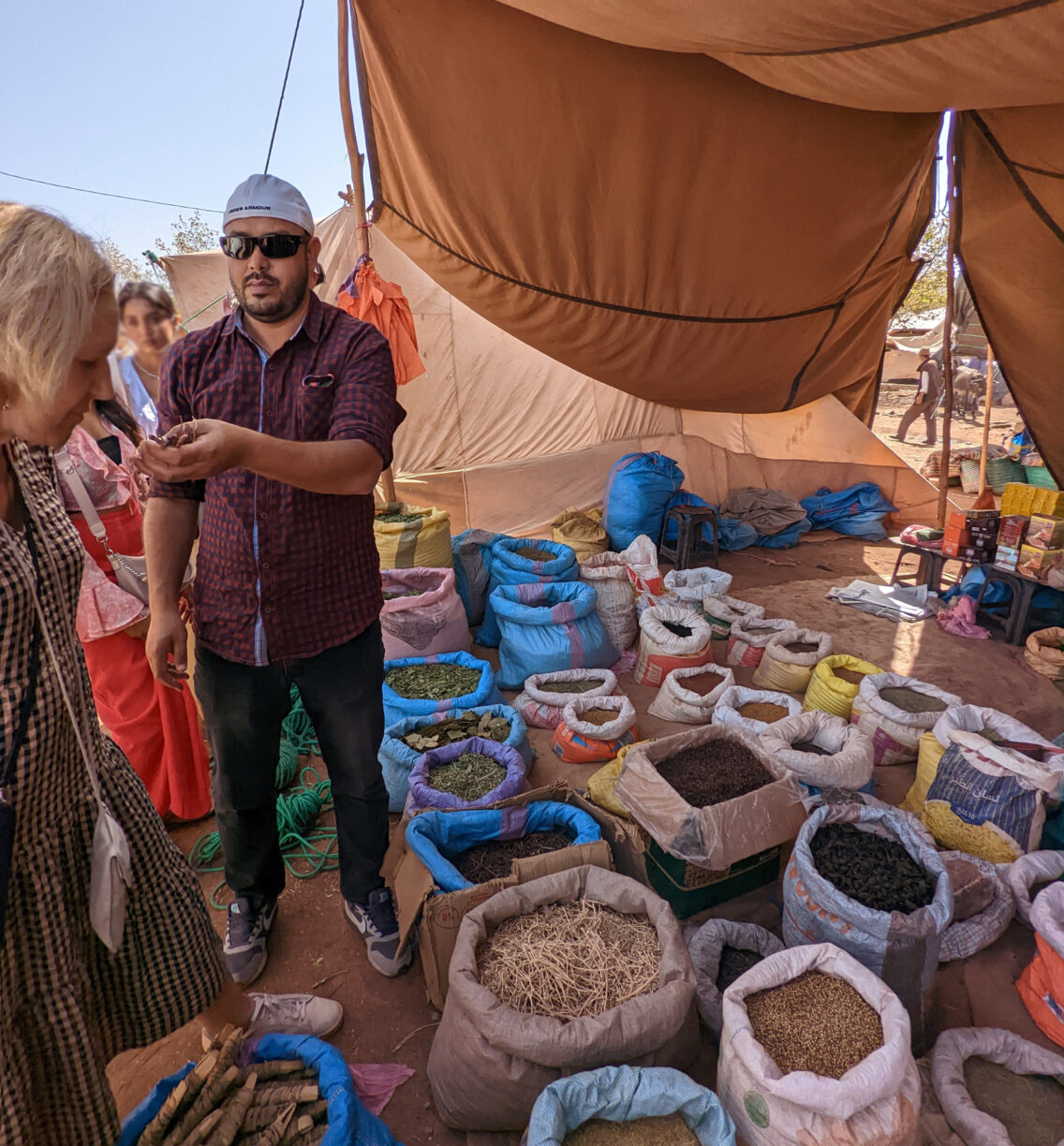A tour guide samples spices for a tour group.