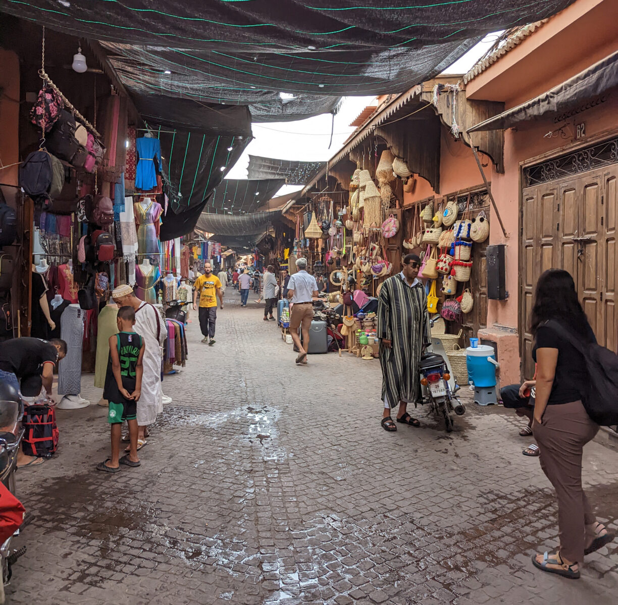 An american travelers walks solo through a moroccan market medina.