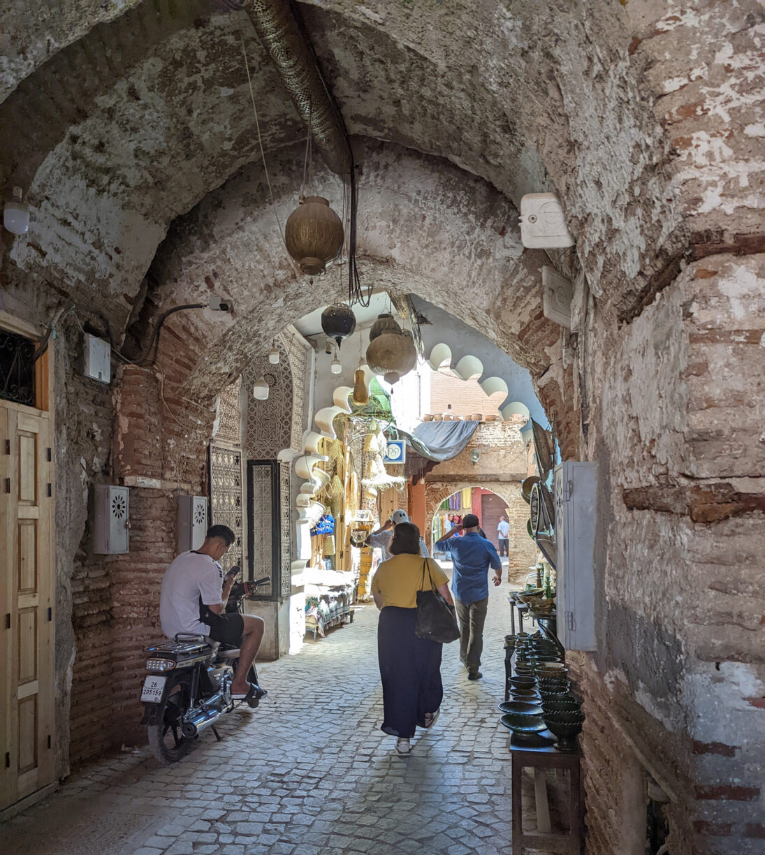 Tourists walk through an ancient walkway in the medina in marrakesh morocco.