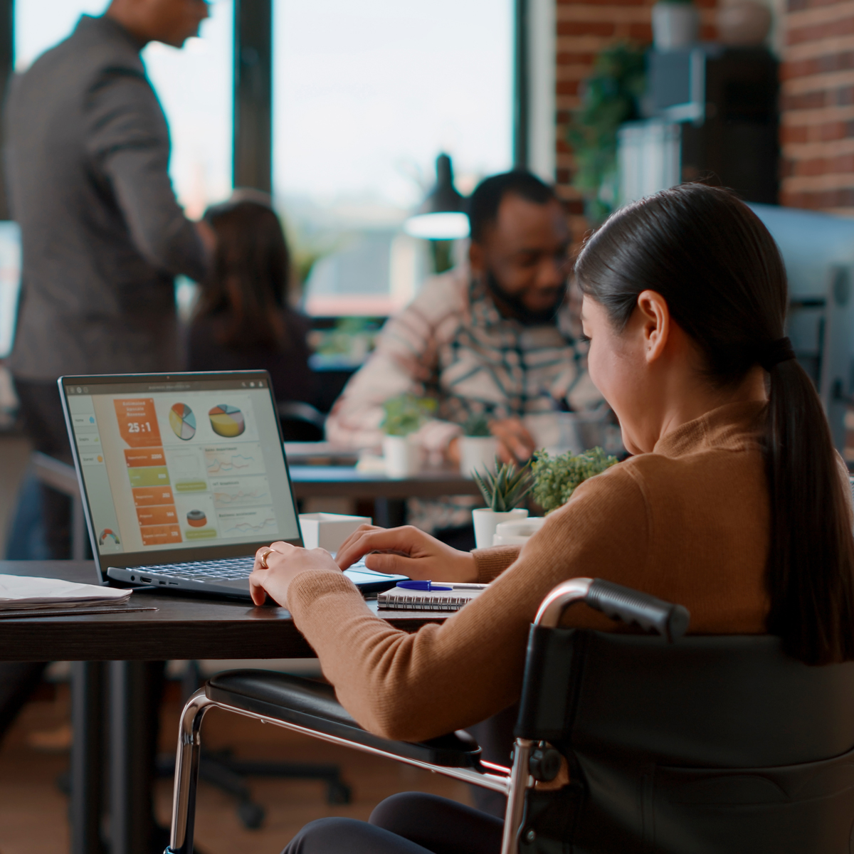 Woman at a desk in an office works on a computer.