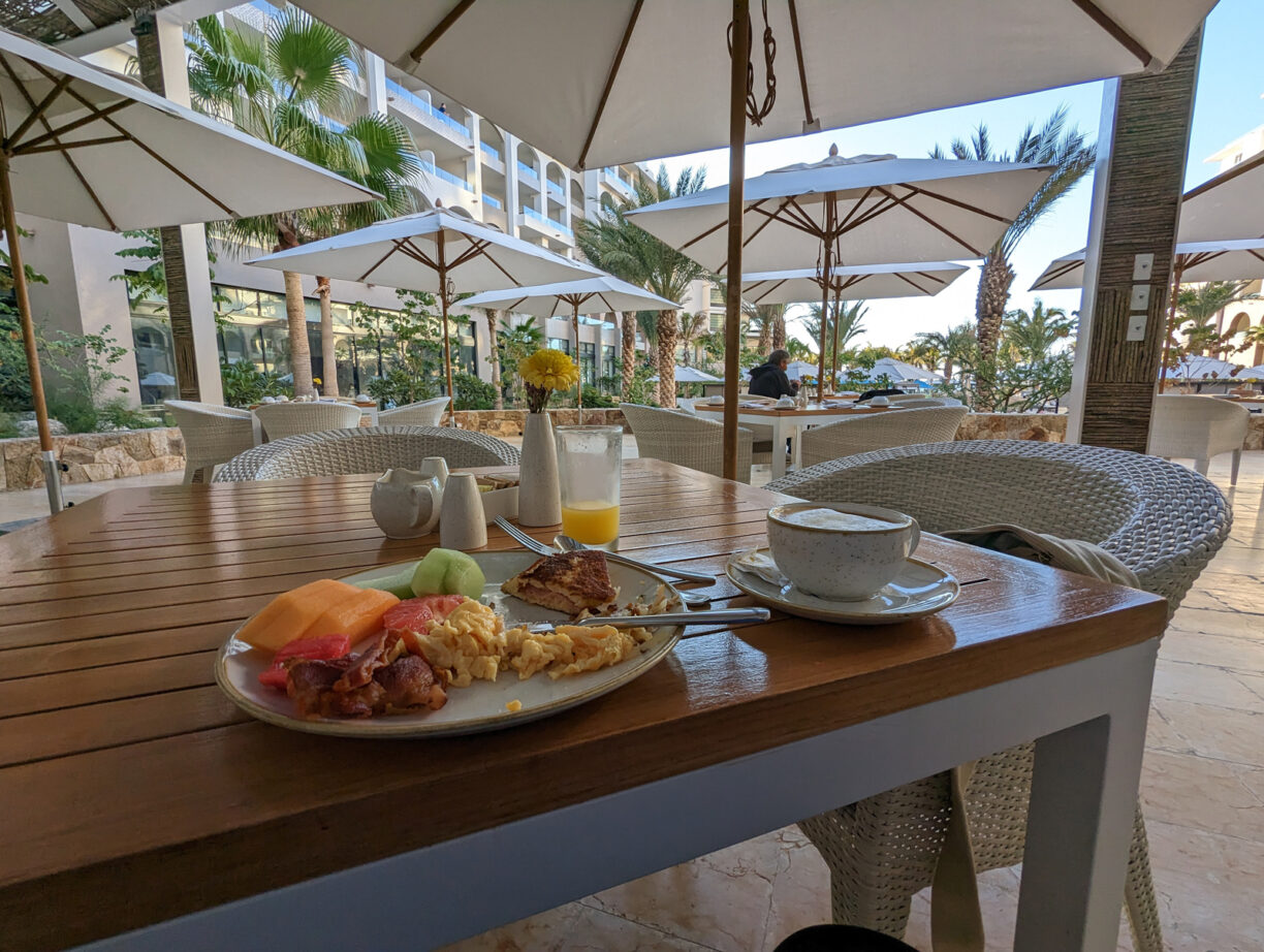 A table in a restaurant with food and a table setting for one person.