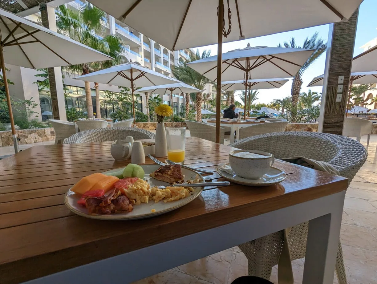 A table in a restaurant with food and a table setting for one person.