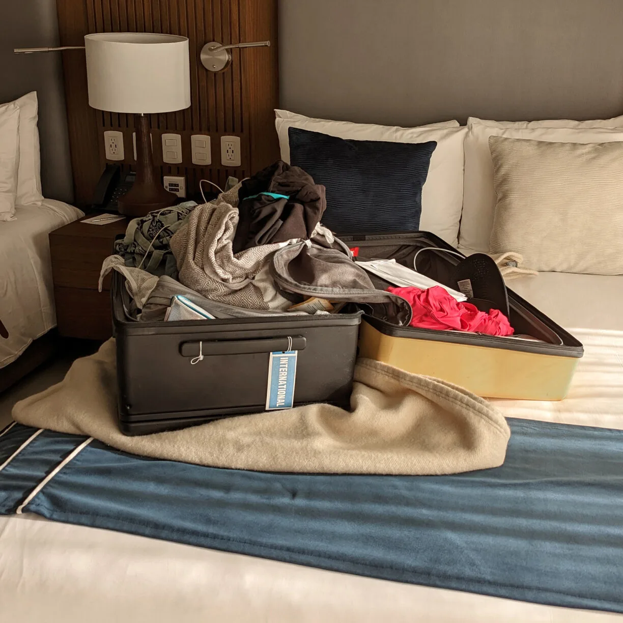 An overflowing suitcase open on a bed.