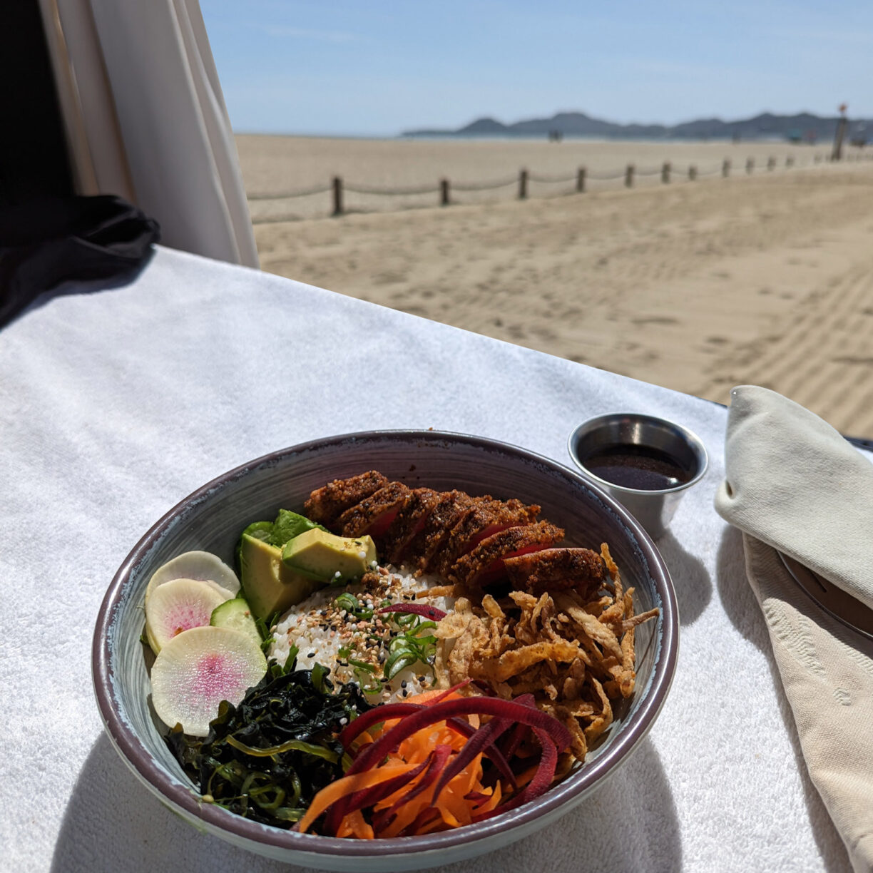 A poke bowl with a beach in the background.