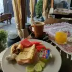 A table in a restaurant in bosnia with breakfast food and a table setting for one person.