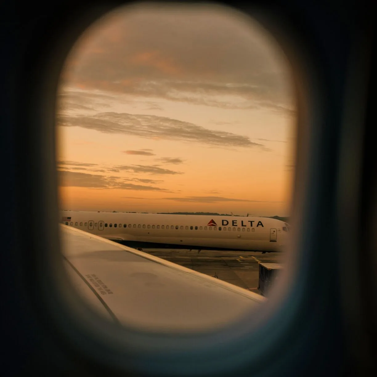 View of a delta plane through a window at golden hour in the evening.