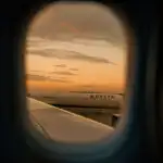 View of a delta plane through a window at golden hour in the evening.