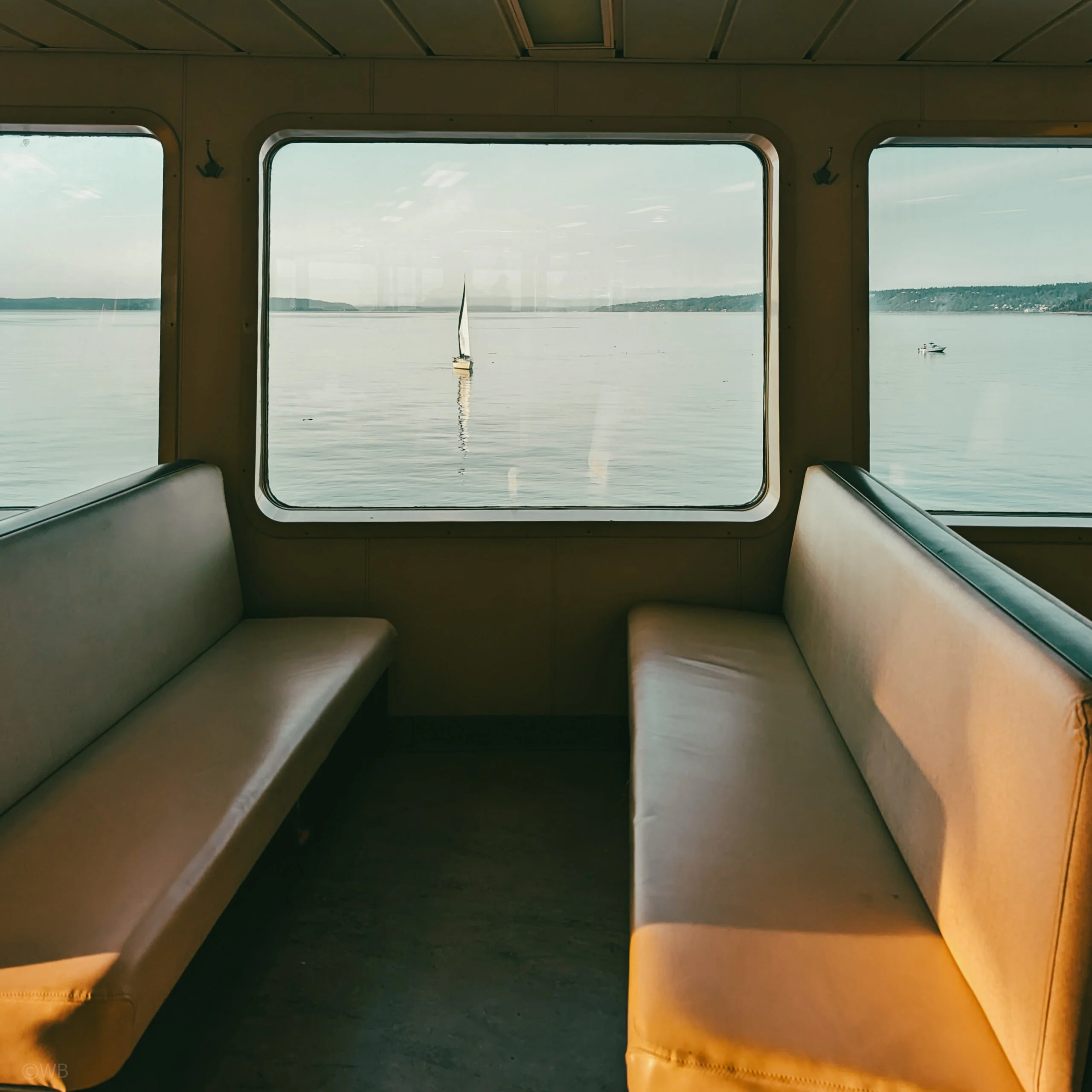 A sailboat as seen from the desk of a washington state ferry.